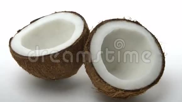 成熟的热带椰子分成两半在白色背景上旋转充满异国情调的水果视频的预览图