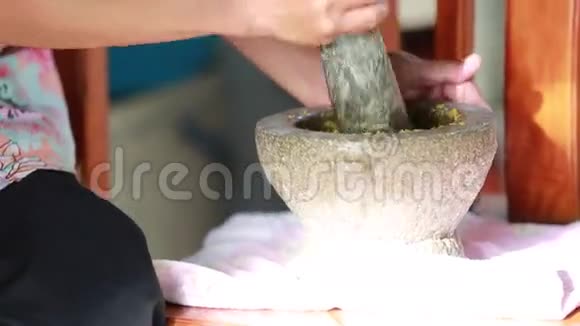 不明身份的人用手在石浆中敲打香料传统的泰国咖喱视频的预览图