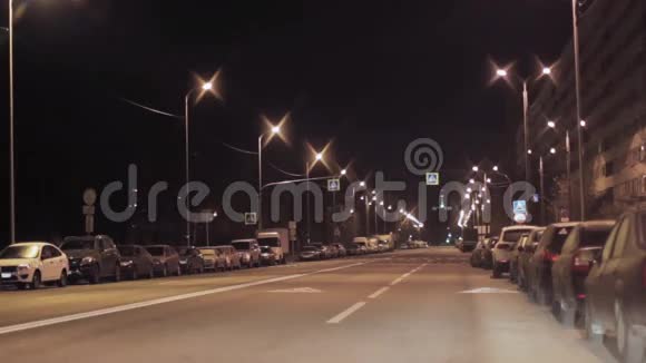 在城市里用手电筒和停放的汽车观看夜间道路没有交通人们视频的预览图