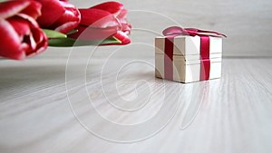 郁金香放在礼品盒旁边戴着红蝴蝶结视频的预览图