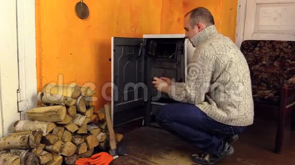 穿毛衣的村民用火柴点燃炉子视频的预览图