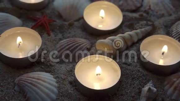 六支蜡烛和一些贝壳在沙滩上视频的预览图
