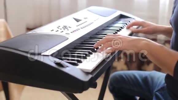 特写男手弹钢琴人播放合成器键盘视频的预览图