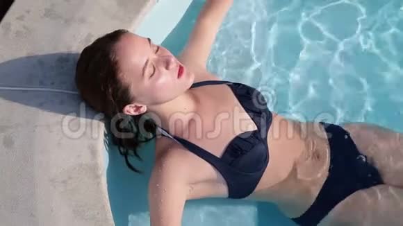 年轻女子在游泳池里放松视频的预览图