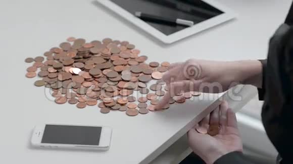 女银行家在白色桌面上计算铁币视频的预览图