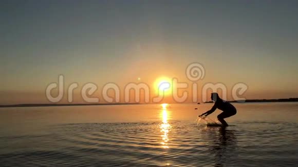一个年轻女孩在日落时泼水视频的预览图