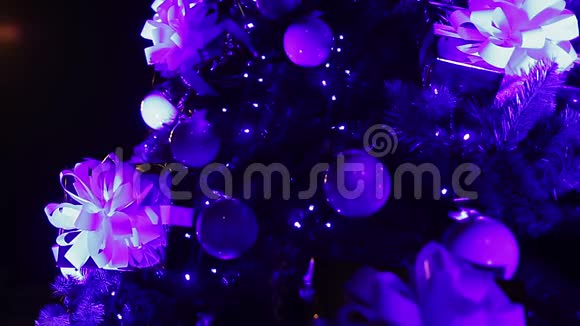 漂亮的装饰品和圣诞树上闪闪发光的花环神奇的夜晚视频的预览图