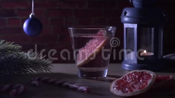 鸡尾酒葡萄柚蜡烛冷杉树枝与圣诞玩具和糖果罐视频的预览图