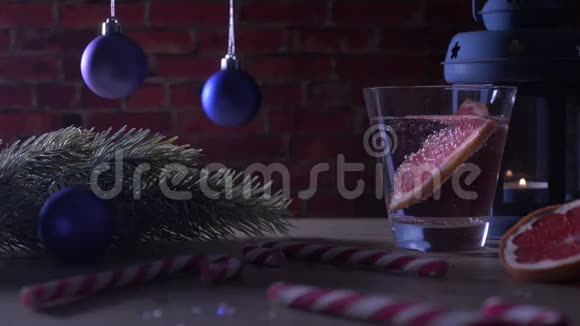 鸡尾酒葡萄柚蜡烛冷杉树枝与圣诞玩具和糖果罐视频的预览图
