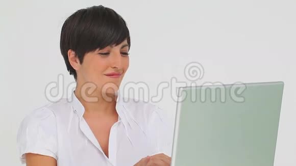 满意的女商人在笔记本电脑上打字视频的预览图