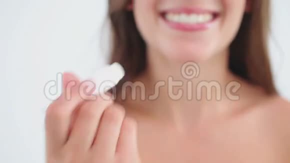 微笑的女人用唇膏抹唇视频的预览图