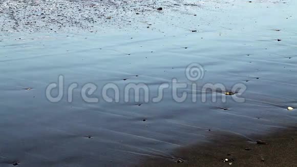 在沙滩上用小石头拍摄的波浪视频的预览图