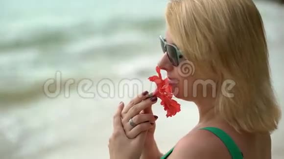 住在海滩上的女人带着红花视频的预览图