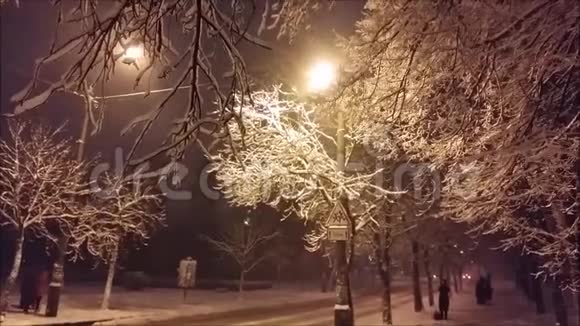 汽车沿着积雪覆盖的傍晚道路行驶在大雪中灯光亮起视频的预览图