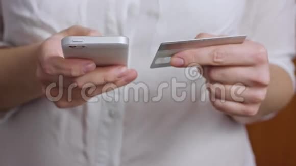 手拿信用卡使用手机智能手机视频的预览图