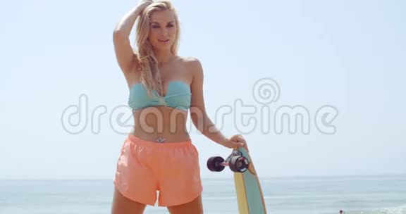美女在海滩上拿着滑板视频的预览图