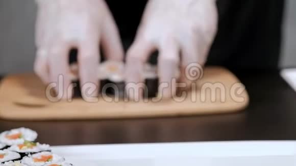 年轻的男性寿司厨师准备日本寿司卷的米饭鲑鱼鳄梨和诺里餐厅厨房双手特写视频的预览图