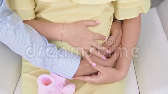 穿着黄色裙子的怀孕女孩和丈夫在室内视频的预览图