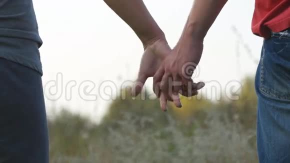 年轻夫妇在户外牵手男人和女人在自然背景上拿起武器男性和女性的双手安慰视频的预览图