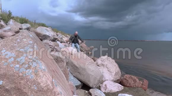 旅行者在岩石海滩斜坡上行走视频的预览图