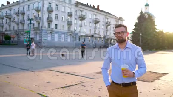 男人在智能手机上说话在街上喝果汁视频的预览图