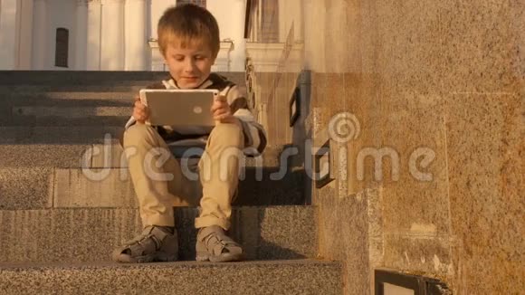 快乐的小男孩在公园里用平板电脑视频的预览图