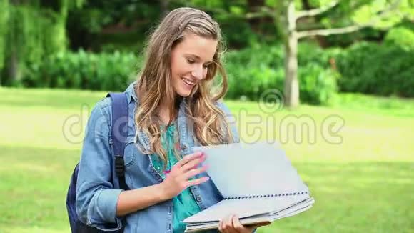 微笑的年轻女人打开她的笔记本视频的预览图