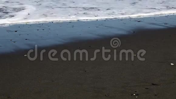 在沙滩上用小石头拍摄的波浪视频的预览图