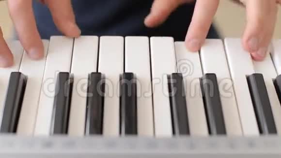 特写男手弹钢琴人播放合成器键盘视频的预览图