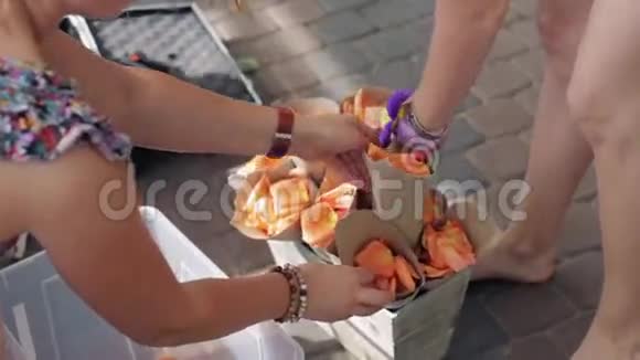 女人的双手用橙色花瓣用小管装饰木花坛夏季视频的预览图