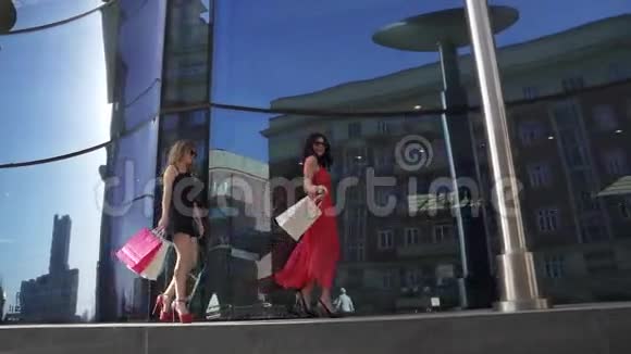 漂亮的年轻女孩靠近商店的窗户最好的朋友花时间在一起金发碧眼的黑发女郎视频的预览图