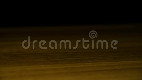 土豆芯片在黑色背景下缓慢运动落在木桌上视频的预览图