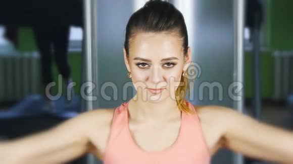 女子在健身房里用举重的蝶形机进行健身训练视频的预览图