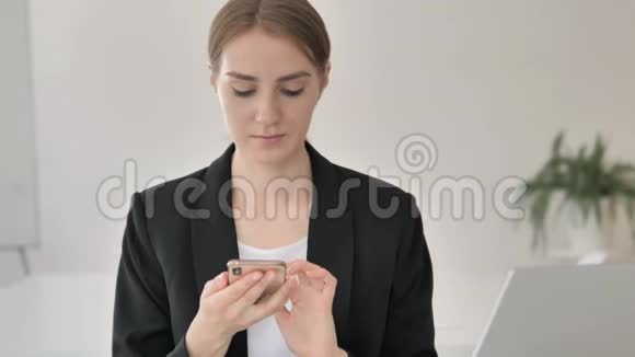 关闭年轻女商人使用智能手机视频的预览图