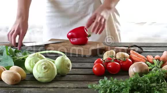 女人切蔬菜女人在木桌上切辣椒视频的预览图