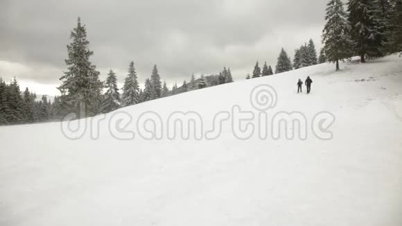 男人和女人在冬天的群山中行走视频的预览图
