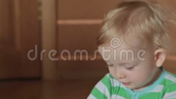 一个可爱的金发小男孩玩动能沙视频的预览图