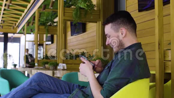 在咖啡馆用智能手机接近男人视频的预览图