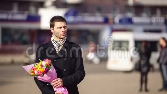 一个男人带着鲜花在城里等着他的女人视频的预览图