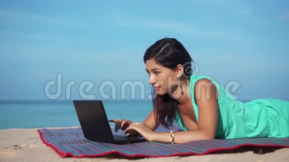 夏日海滩上有笔记本电脑的快乐女人视频的预览图