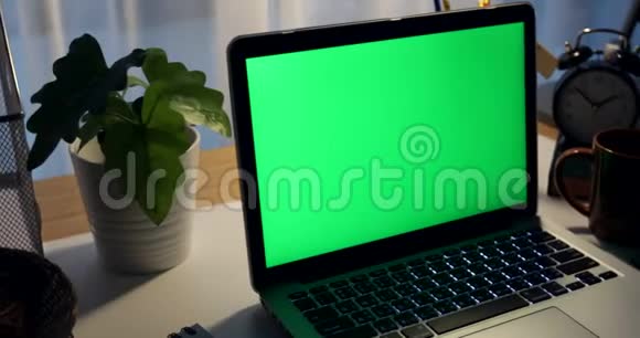 带有绿色屏幕的笔记本电脑黑暗的办公室多莉向左向右移动完美地放置你自己的图像或视频技术绿屏视频的预览图