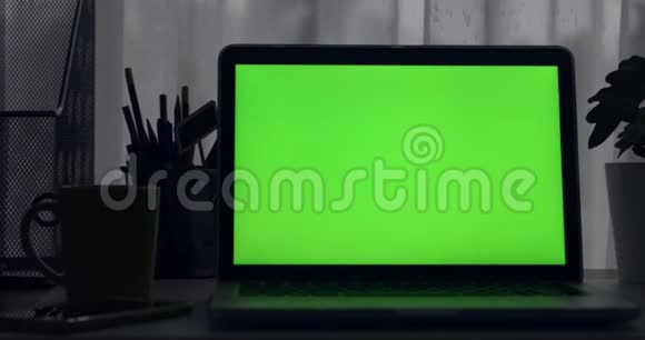 带有绿色屏幕的笔记本电脑黑暗的办公室多莉向左向右移动完美地放置你自己的图像或视频技术绿屏视频的预览图
