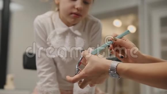 牙医给一个小女孩做咨询让她知道如何用假牙刷牙特写视频的预览图