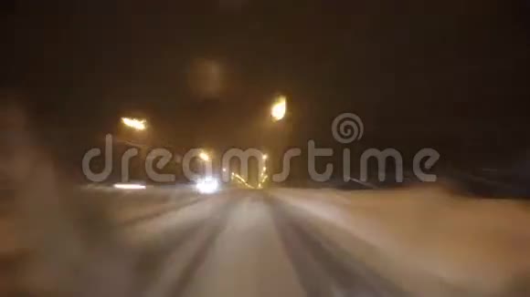 冬天下雪时汽车在夜间城市道路上行驶视频的预览图