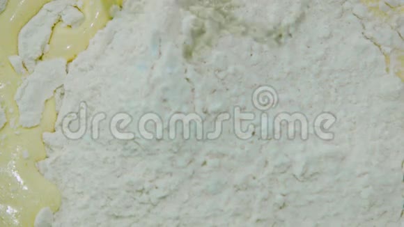 将面粉筛于海绵混合物表面用手搅拌视频的预览图