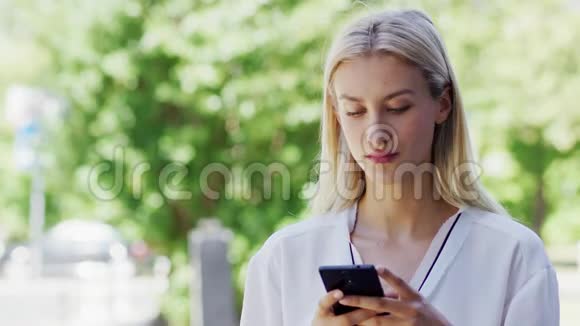 年轻女士在街上使用智能手机视频的预览图