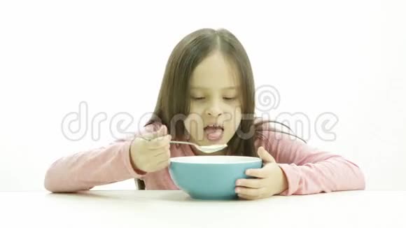 一个可爱的女孩穿着粉色上衣吃麦片视频的预览图
