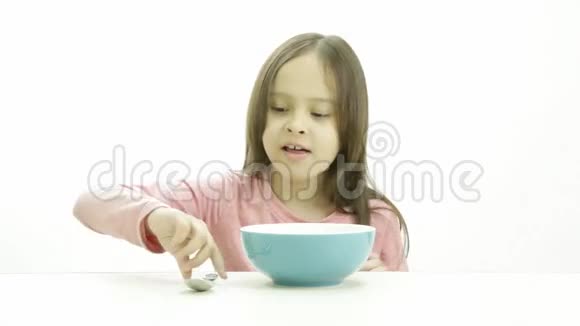 一个可爱的女孩穿着粉色上衣吃麦片视频的预览图