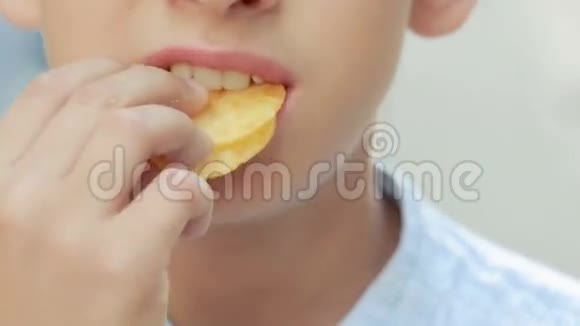在街上吃薯片的男孩小男孩吃垃圾食品视频的预览图