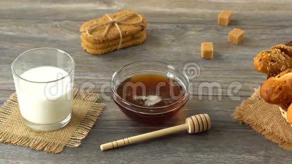 蜂蜜牛奶饼干和新鲜面包放在乡村木桌上乡村早餐视频的预览图